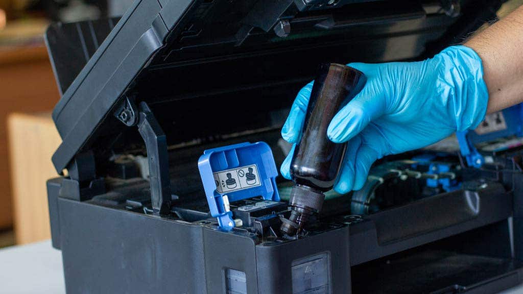 photo of a person refilling black ink in a printer