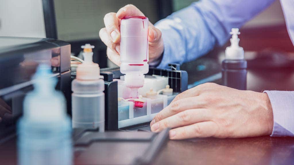 Office worker refilling a printer with dye-based ink