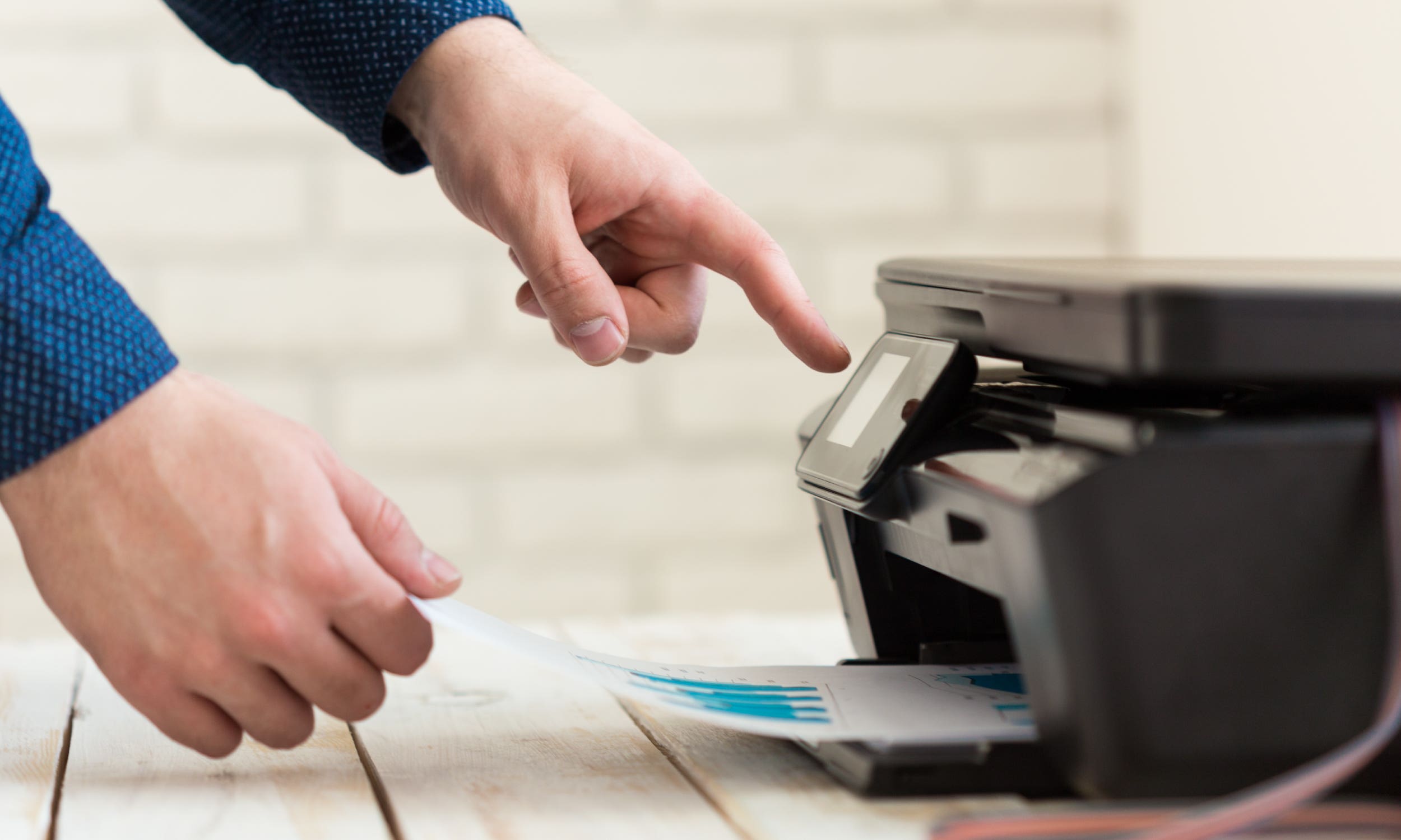 person pressing a printer button