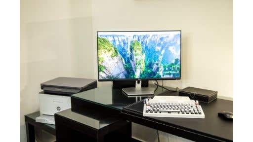 white HP printer behind an office desk