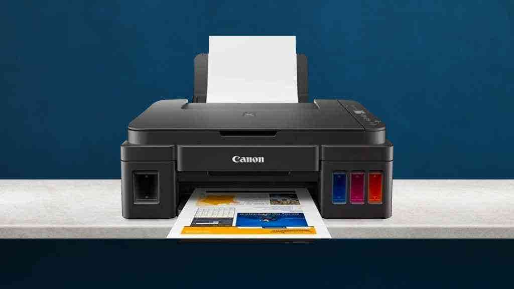black Canon printer on top of a white table