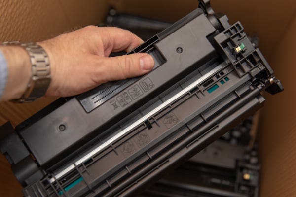 man putting empty ink toners in a box