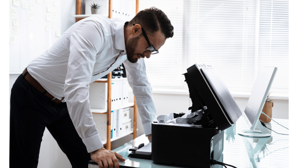 man standing over a black printer