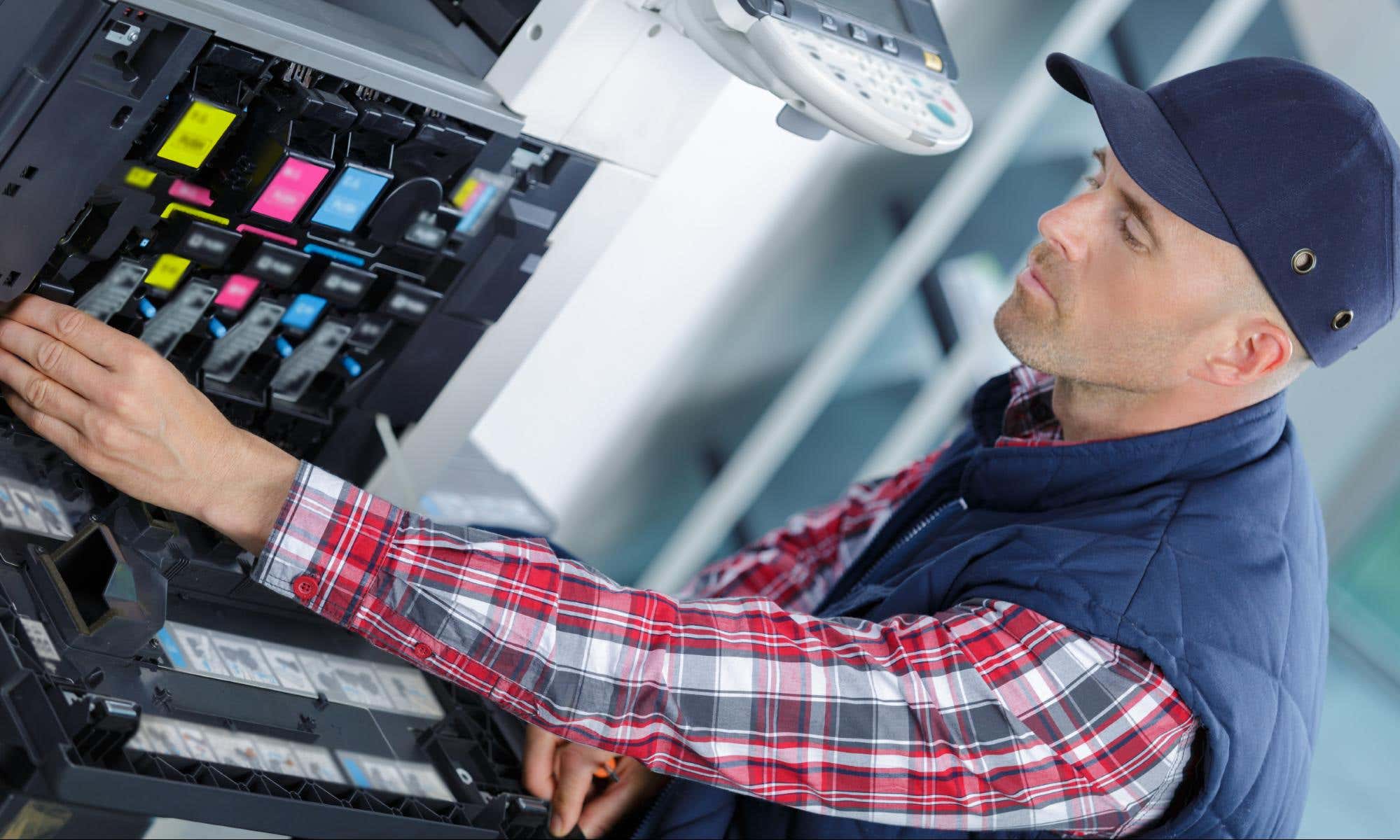 man checking a printer's internal components
