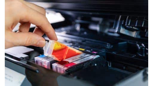 person_replacing_printer_ink_cartridge