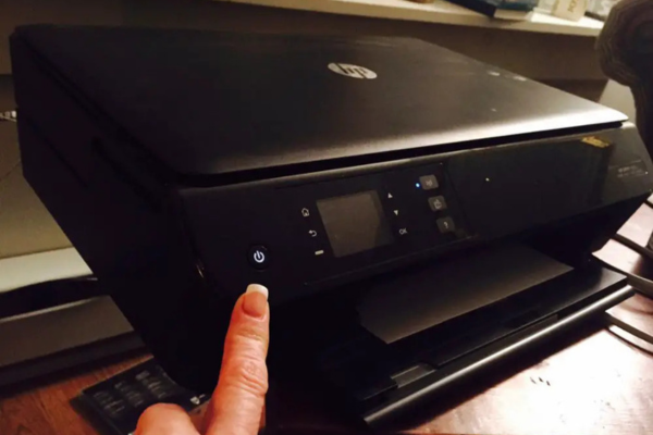 Person turning on a printer